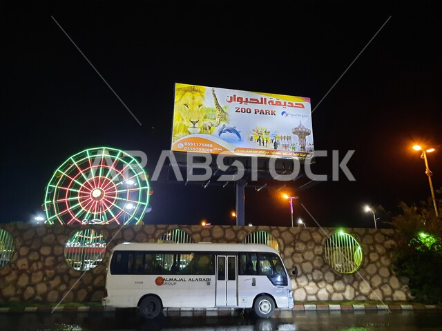 Spending a good time in the amusement park, a bus that parks next to the park, a sign with cartoon characters and drawings indicating the amusement park in the city of Taif, tourist parks and gardens in the Kingdom of Saudi Arabia, a distinctive family destination.