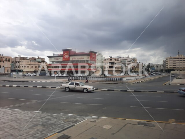 الشوارع المعبدة في المملكة العربية السعودية، تصاميم وأبنية حديثة، المعالم الفريدة في مدينة الطائف، حركة مرورالسيارات في الطرقات، فنون الهندسة المعمارية في البناء، أجواء شتوية غائمة، موقع لاستقطاب الزوار والسائحين.