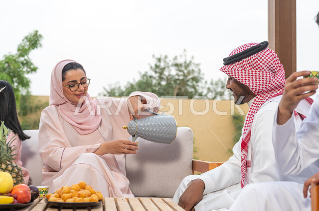 قضاء أوقات ممتعه في أحد الشاليهات، امرأة عربيه خليجيه سعودية محجبة تقوم بصب القهوة العربية، أجواء عائلية مليئة بالود والمحبة ،منتج وطني سعودي محلي، تقديم المشروبات الساخنه الشهيه للأخوة، نزهه في الهواء الطلق، حسن الضيافة والاستقبال وإكرام الضيوف