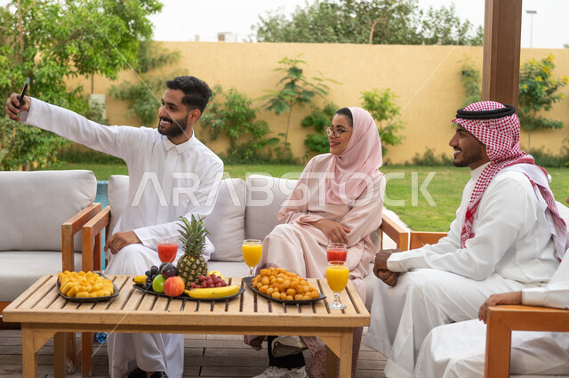 الاستمتاع في العطلة الصيفيه مع الاسرة، ايماءات السرور أثناء توثيق اللحظات السعيدة بالتقاط الصور التذكارية عبر الجوال، عائلة عربيه خليجيه سعودية تقضي أوقات الفراغ في إحدى الشاليهات، أجواء مليئة بالحب والود، الاهتمام والاعتناء بالأهل، التنزه في الهواء الطلق