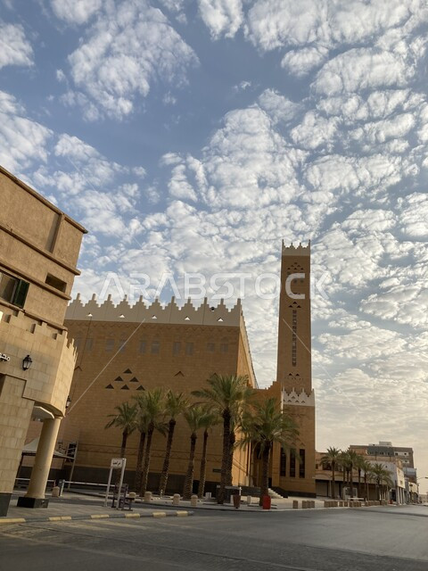 الطراز التاريخي التراثي القديم لبناء الجوامع في السعودية, الفن الهندسي المعماري لمبنى مسجد بريدة الكبير في وسط الديرة بمنطقة القصيم, الطرقات والشوارع المعبدة في الأماكن السياحية, السماء الملبدة بالغيوم القطنية البيضاء في وضح النهار, معالم دينية اسلامية مشهورة