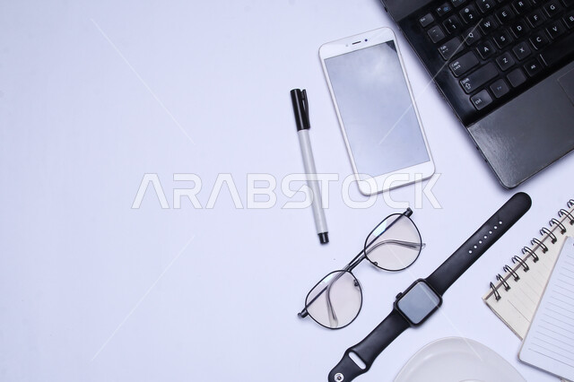 A group of modern technical devices on the office table, the development of technology and technology, the use of smart and advanced devices to accomplish work tasks, companies and offices in the Kingdom of Saudi Arabia, office freelance work, tools and personal items.