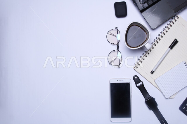 A group of modern technical devices on the office table, the development of technology and technology, the use of smart and advanced devices to accomplish work tasks, companies and offices in the Kingdom of Saudi Arabia, office freelance work, tools and personal items.