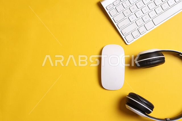 لوحة المفاتيح وسماعات الرأس على طاولة المكتب الصفراء , تطور التقنيه والتكنولوجيا, استخدام الأجهزة التقنية الذكية والمتطورة للدراسة وحضور المحاضرات اونلاين, شركات ومكاتب في المملكة العربية السعودية, أعمال حره مكتبيه, أدوات وأغراض شخصية.