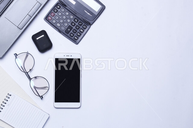 استخدام الأجهزة الذكية والمتطورة لإنجاز مهام العمل, مجموعه من الأجهزه التقنيه الحديثه على طاولة المكتب, تطور التقنيه والتكنولوجيا, شركات ومكاتب في المملكة العربية السعودية, أعمال حره مكتبيه, أدوات وأغراض شخصية، خلفية رمادية. 
