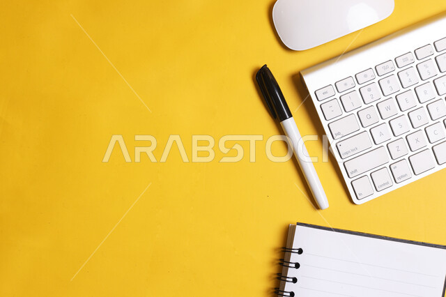 لوحة مفاتيح لجهاز الحاسوب على طاولة المكتب, مفهوم التعليم عن بعد باستخدام التقنيه والتكنولوجيا, استخدام الأجهزة الذكية والمتطورة للدراسة وحضور المحاضرات اونلاين, شركات ومكاتب في المملكة العربية السعودية, أعمال حره مكتبيه, تسجيل وتدوين الملاحظات المهمة، خلفية صفراء.