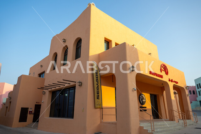 الفن الهندسي المعماري للمباني والفنادق والشاليهات على شاطئ البحر، تعزيز صناعة السياحة البحرية المحلية في قطر، صورة مقربة لمبنى في ميناء الدوحة القديم بتصاميم وألوان تعكس التراث والتاريخ القطري، مركز جذب السياح من شتى أنحاء العالم