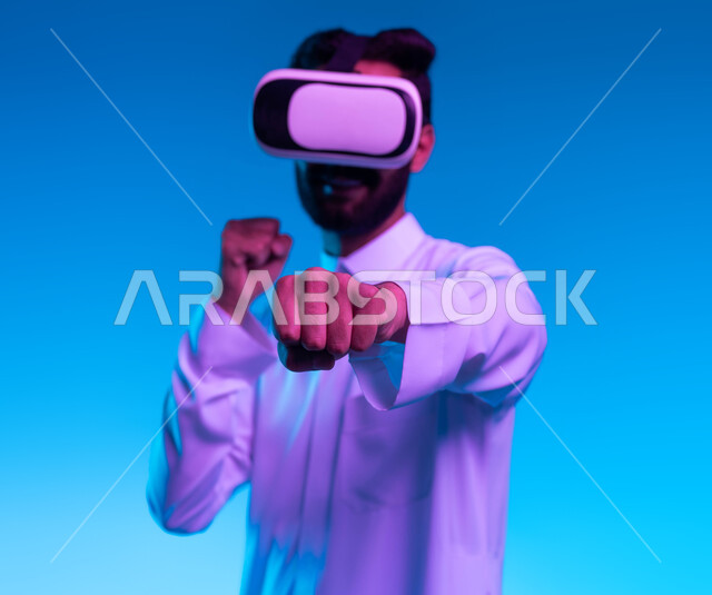 Practicing self-defense using technological techniques, discharging negative energy, practicing combat movements through video games, a close-up portrait of a young Saudi Gulf Arab man wearing a traditional thobe and virtual reality glasses with boxing and wrestling gestures, a blue background.