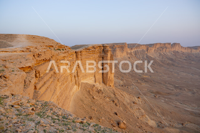 The Tuwaiq mountain range in Najd at sunset, desert nature and mountainous terrain in Saudi Arabia, famous natural tourist attractions, the rocky edge of the apocalypse in te Riyadh desert in the Kingdom of Saudi Arabia