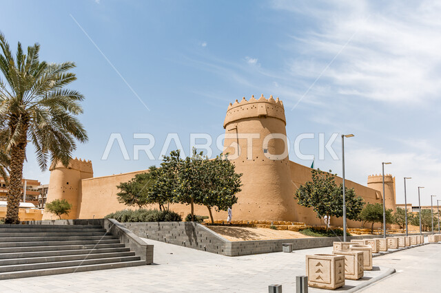  فن الهندسة المعمارية والمباني الطينية القديمة، أشجار النخيل حول متحف قصر المصمك التاريخي في مدينة الرياض في وضح النهار، الاهتمام بالتشجير والنباتات الخضراء في الاماكن الاثرية السياحية في المملكة العربية السعودية، معالم الرياض التراثية