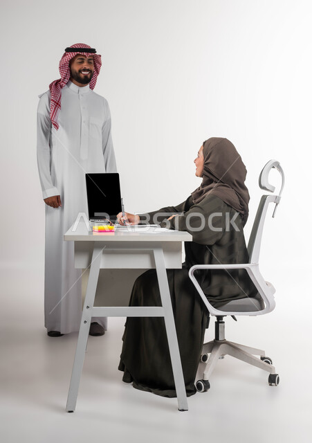 استخدام التقنيات والوسائل الحديثة، تعليم الموظفين الأساليب الجديدة لتحقيق أهداف الشركة، إدارة شؤون الأعمال وتنظيمها، بورتريه لزميلين عربيين سعوديين خليجيين يقومان بمناقشة و تنظيم المهام بإيماءات السرور، بيئة عمل مريحة و ناجحة، خلفية بيضاء