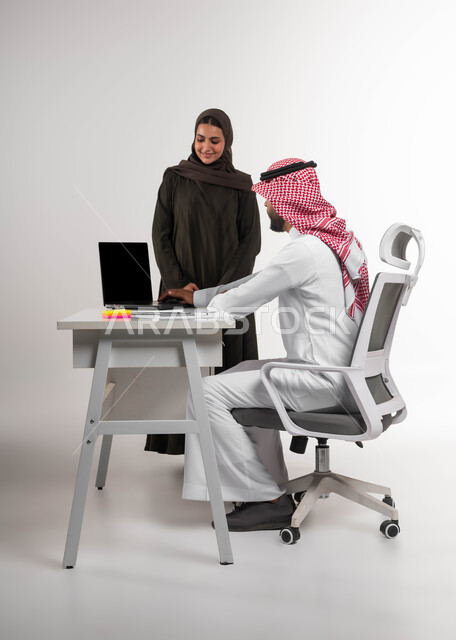 توحيد الجهود لتحقيق أهداف الشركة، اكتساب الخبرة وتوسيع شبكة العلاقات المهنية، بورتريه لزميلين عربيين خليجيين سعوديين مبتسمين يقومان بإنجاز المهام عبر الحاسوب المحمول، التعاون والعمل الجماعي، تدريب الموظفين على أساليب العمل الجديدة، خلفيه بيضاء
