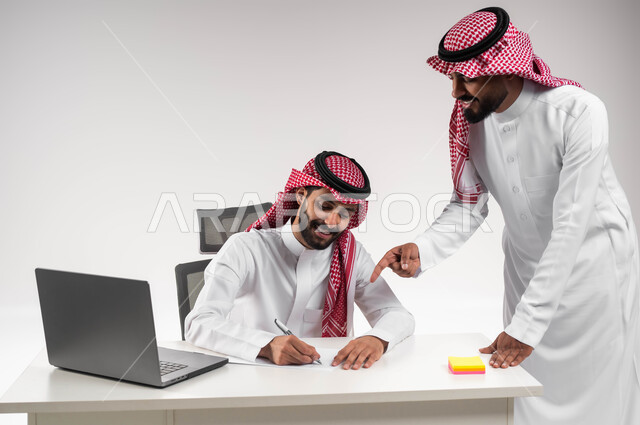 عقد صفقات شراكة جديدة، مفهوم الإدارة المتعاونة، بورتريه لموظفين عربيين خليجيين سعوديين مبتسمين يرتديان الشماغ والثوب التقليدي يناقشان أمور العمل باستخدام الأوراق والبيانات، الوحدة والتفاعل الجماعي لتحقيق أهداف الشركة وحل المشكلات، خلفية بيضاء.