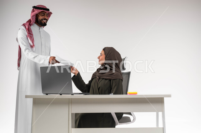 بيئة عمل مريحة و ناجحة، تسليم المشروع بالوقت اللازم، تحقيق أهداف الشركة بالوقت المطلوب، إدارة شؤون الأعمال وتنظيمها، بورتريه لموظف عربي خليجي يرتدي الزي التقليدي يقوم بتقديم الأوراق لمديرته بإيماءات السرور، خلفية بيضاء