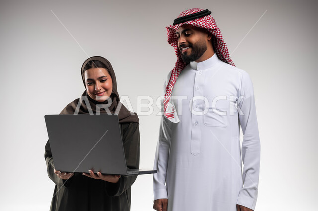 الانتباه للملاحظات وتطبيقها عبر الحاسب المحمول, العمل الجماعي وروح الفريق الواحد، متابعة إنجازات مهام الموظفين، تعلم اساليب العمل والتطوير المهني، بورتريه مقرب لزميلين عربيين خليجيين سعوديين يقومان بتطوير الخطط وحل المشكلات لتحقيق أهداف الشركة، خلفيه بيضاء