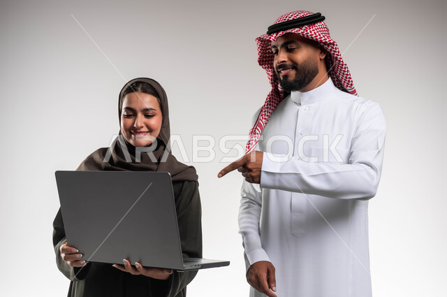 العمل الجماعي وروح الفريق الواحد، متابعة إنجازات مهام الموظفين، تعلم اساليب العمل والتطوير المهني، بورتريه مقرب لزميلين عربيين خليجيين سعوديين يقومان بتطوير الخطط وحل المشكلات لتحقيق أهداف الشركة، الانتباه للملاحظات وتطبيقها عبر الحاسب المحمول، خلفيه بيضاء