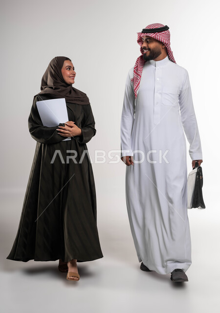 الرغبة في تعلم اساليب العمل والتطوير المهني، بورتريه لزميلين عربيين خليجيين سعوديين يقومان بالمشي ومناقشة المهام والأعمال، الانتباه للملاحظات وتطبيقها، تطوير الخطط وحل المشكلات لتحقيق أهداف الشركة، العمل الجماعي وروح الفريق الواحد، صورة الجسم بالكامل، خلفيه بيضاء