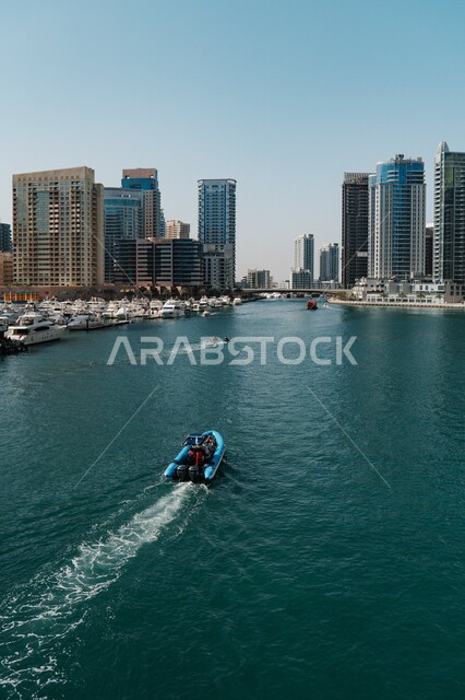 Distinctive water landscapes, modern architecture of towers and skyscrapers in the United Arab Emirates, a close-up of the ship cruising in the Marina Sea in Dubai, attractions for tourists from abroad