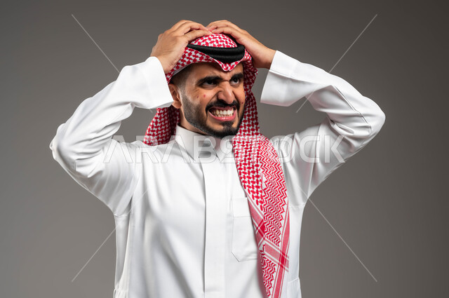 الشعور بالآلام  والأوجاع, بورتريه مقرب لرجل عربي خليجي سعودي يرتدي الثوب والشماغ التقليدي يضع يديه على رأسه بإيماءات الوجع الشديد, بثور منتشرة على بشرة الوجه, الاصابة بالحساسية الجلدية والمشاكل الصحية, الأمراض والتهجيات وفرط التحسس, خلفية رمادية