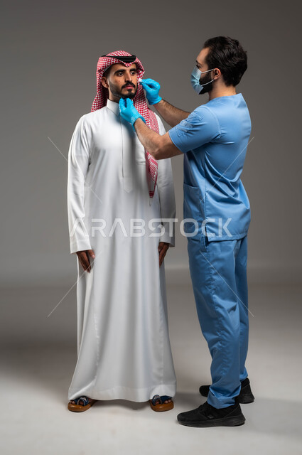 الإصابة بالحساسية الجلدية والمشاكل الصحية, بثور منتشرة على بشرة الوجه, بورتريه لطبيب مختص عربي خليجي سعودي يعالج الأمراض والتهجيات الجلدية عند رجل يرتدي الزي التقليدي, صورة الجسم بالكامل, خلفية رمادية