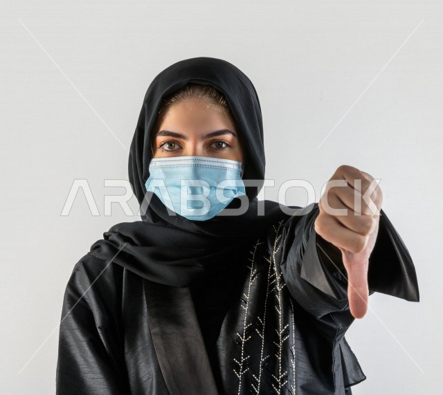 بورتريه لشابة سعودية تقوم بارتداء الكمامة لتجنب تفشي الفايروس ، اتباع اجراءات السلامة بارتداء القفازات ، تجنب انتشار العدوى ، خلفية بيضاء
