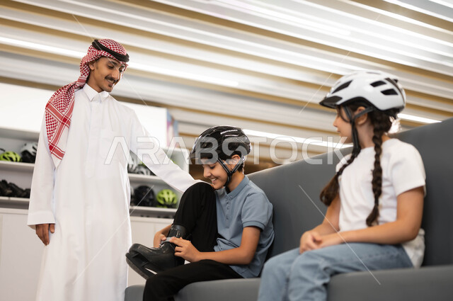 قضاء وقت ممتع في تطوير المهارات الرياضية، ايماءات الحماس لبدء السباقات، اللعب في ساحات التزلج، فتاة و ولد عربي خليجي سعودي يقوم بارتداء الزلاجات و خوذة الحماية، موظف سعودي يقوم بتبادل الأحاديث مع الأطفال بتعابير البشاشة في أحد الأماكن الترفيهيه في السعودية