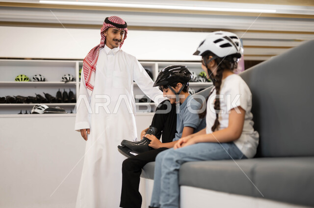 تطوير المهارات الرياضية في اللعب في ساحات التزلج، ايماءات الحماس لبدء السباقات، فتاة و ولد عربي خليجي سعودي يقوم بارتداء الزلاجات و خوذة الحماية، موظف سعودي يقوم بتبادل الأحاديث مع الأطفال بتعابير البشاشة في أحد الأماكن الترفيهيه في السعودية