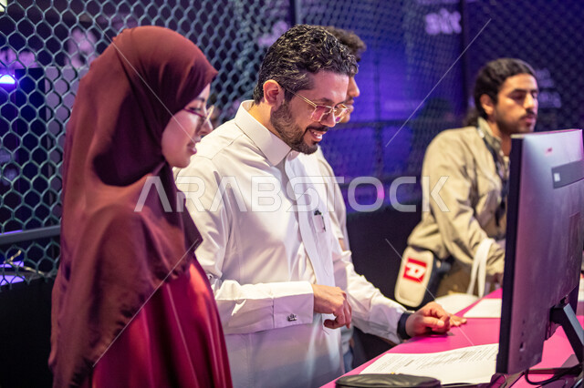 معرض بلاك هات للامن السيبراني، فعاليات موسم الرياض, توفير فرص عمل حقيقية في نظام بيئي متفاعل ،صورة مقربة لامرأة ورجل عربيان خليجيان سعوديان يقومان بقراءة التعلميات للتعرف على استراتيجيات لمواجهة التهديدات السيبرانيه، استكشاف الابتكارات في مجال السايبر سكيوريتي