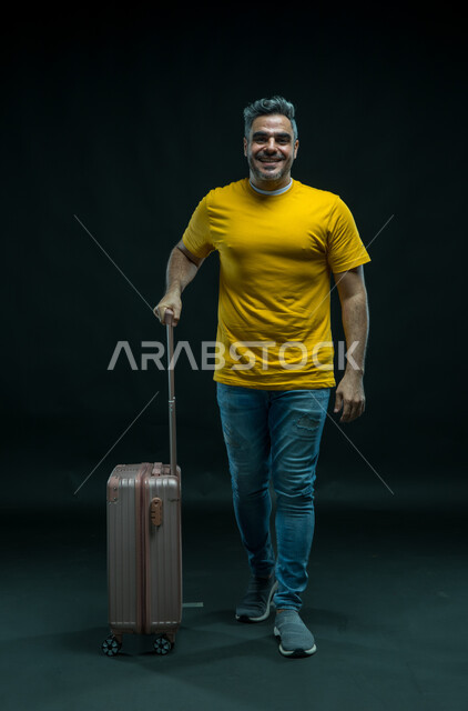 Gestures of activity and vitality and preparation for an enjoyable summer trip, gestures of joy and happiness, a portrait of a smiling Saudi Arabian Gulf man wearing a casual outfit looking at the camera and holding a travel bag in his hand, a feeling of enthusiasm and joy, a full body portrait, black background.