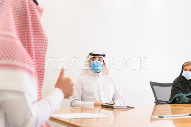اجتماع اداري مع مجموعة من الأشخاص السعوديين الخليجيين في غرفة الاجتماعات  ، اجتماع رجال اعمال و سيده اعمال سويا داخل الشركة ،  شركة سعودية ، عمل خليجي ،  فريق العمل 