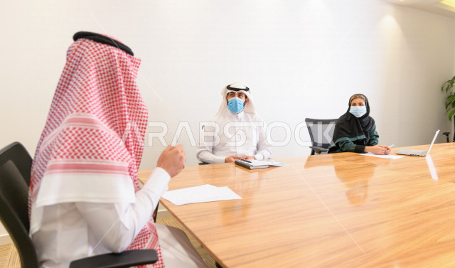 اجتماع اداري مع مجموعة من الأشخاص السعوديين الخليجيين في غرفة الاجتماعات  ، اجتماع رجال اعمال و سيده اعمال سويا داخل الشركة ،  شركة سعودية ، عمل خليجي ،  فريق العمل 