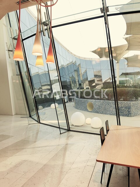 Illuminated lamps and glass windows, a café inside the Ithra Library, the largest public library in Saudi Arabia, a cultural beacon and famous tourist attraction, a place for readers and lovers of science, books and knowledge, the King Abdulaziz World Cultural Center in the city of Dhahran in the Kingdom.