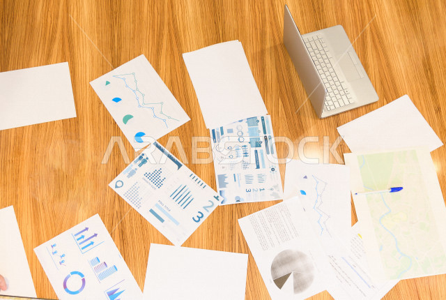 اجتماع اداري مع مجموعة من الأشخاص السعوديين الخليجيين في غرفة الاجتماعات  ، اجتماع رجال اعمال و سيده اعمال سويا داخل الشركة ، مجموعة من الاوراق المبعثرة على طاولة الاجتماعات ،  شركة سعودية ، عمل خليجي ،  فريق العمل 