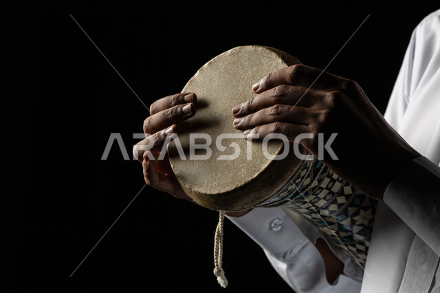 قرع الطبول باستخدام الآلات الايقاعية، مواهب فنية موسيقية، بورتريه مقرب لرجل عربي سعودي خليجي فنان يقوم بممارسة هواية الطبل على الطبلة السعودية، تقديم البرامج والفنون الغنائية والفن المسرحي، خلفية سوداء