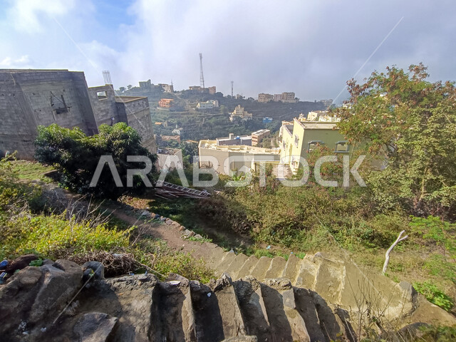 الاشجار والنباتات الخضراء، السماء المليئة بالغيوم البيضاء فوق جبال الفيفاء في جازان في السعودية، اماكن ومعالم سياحية مشهورة جنوب المملكة، البيوت والمباني السكنية الريفية، القمم والمرتفعات الجبلية ,خلفية الطبيعة