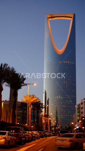 العمل على تنمية وتطور الأبراج والمباني في المملكة العربية السعودية, حركة المرور والسيارات في الطرق والشوارع العامة، الفن الهندسي المعماري للمنشآت وناطحات السحاب في مدينة الرياض, صورة مقربة لمبنى برج المملكة المضاء في وقت الغروب, أماكن ومعالم سياحية مشهورة