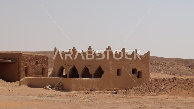 Old, broken houses made of bricks in broad daylight, the concept of primitive life in the desert, traditional mud houses in the Kingdom of Saudi Arabia, ancient monuments and places, historical villages and cities.