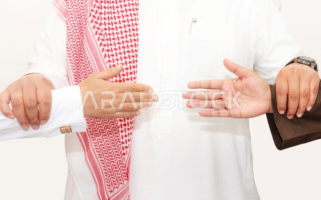مفهوم الصفح والتسامح، محاولة الاصلاح بين شخصين، بورتريه مقرب لرجل عربي خليجي سعودي يرتدي الشماغ والثوب التقليدي يقوم بمسك أيدي شاب وإمرأة، منع الملامسة والمصافحة للوقاية من الامراض وانتشار الاوبئة، خلفية بيضاء