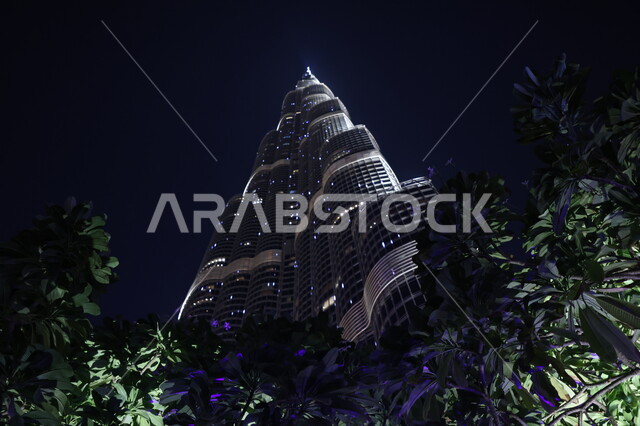 الفن الهندسي المعماري للأبراج وناطحات السحاب، العمل على تنمية وتطوير الأبراج والمباني، الاهتمام بالتشجير في المدن السياحية والاماكن العامة، صورة من الأسفل لبرج خليفة المضاء في وقت الليل في إمارة دبي، معالم سياحية مشهورة في الإمارات العربية المتحدة