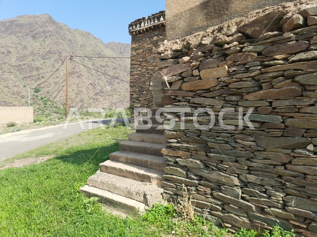 Stairs and ladders made of volcanic rocks, buildings made of stones and tree trunks, mountain peaks and heights in the historic village of Wadi Al-Rama in the Al-Baha region in Saudi Arabia, famous mountainous tourist attractions in the Kingdom, the traditional architectural design of the village houses