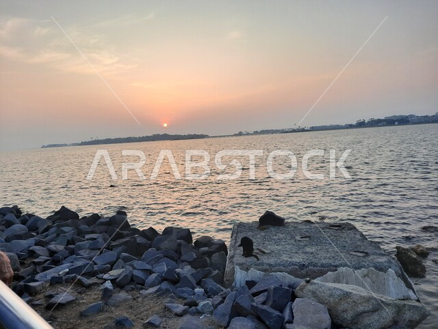 الواجهة البحرية في السعودية، منظرغروب الشمس على كورنيش جدة، الاستمتاع برحلة صيفية مميزة ، مركز جذب واستقطاب السائحين من العالم، الأماكن السياحية الترفيهية في المملكة، الحجار والصخور على الشاطئ، خلفيات الطبيعة.