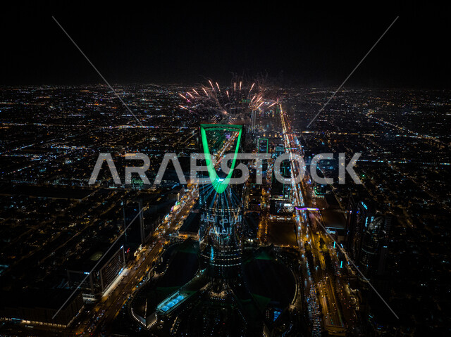 Illuminating the Kingdom Tower in green at night during the celebration on the occasion of winning Expo 2030 in Saudi Arabia, development and economic growth of towers and skyscrapers, cultural performances and recreational activities, a picture from above of modern architectural engineering art.