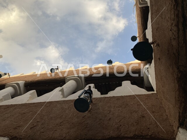 الفوانيس الشعبية العربية السعودية التقليدية, الفوانيس المعدنية المعلقة على الجدران الطينية داخل متحف العقيلات في مدينة بريدة في منطقة القصيم, أداوت إنارة بدائية تراثية تقليدية, الفن الهندسي والتصميم الداخلي على الطراز القديم