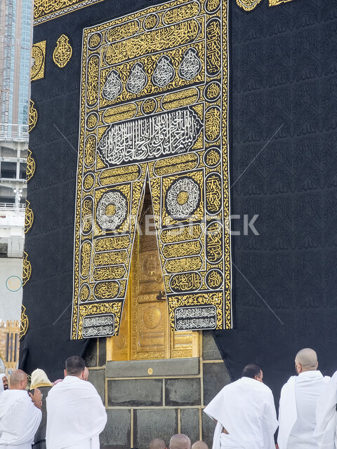 حجاج بيت الله يقومون بأداء العبادات والتقرب إلى الله تعالى، صورة مقربة لكسوة الكعبة المشرفة مغطاة بقماش من  الحرير الأسود مزينة بنقوش و زخارف من خيوط ذهبية اسلامية ونصوص قرآنية ،المسجد الحرام في مكة المكرمة
