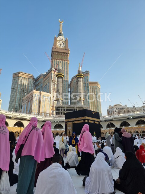 قدوم المسلمين من جميع أنحاء العالم لأداء مناسك الحج والعمرة، الفن الهندسي المعماري لبرج الساعة المكي المطل على المسجد الحرام، الطواف حول الكعبة المشرفة، حجاج بيت الله في الحرم المكي الشريف في مكة المكرمة في السعودية، أماكن ومعالم دينية اسلامية مقدسة
