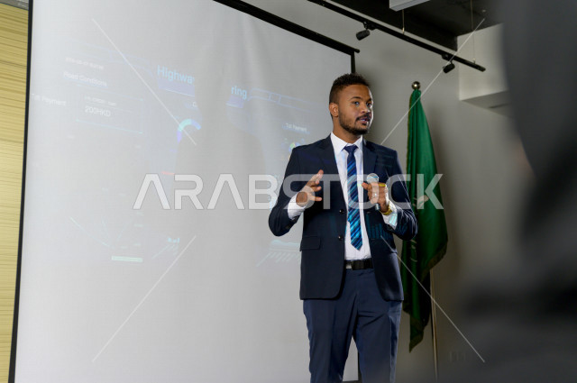 صورة مقربة لرجل اعمال سعودي متحدث و مشارك في الدورة التدريبية و يرتدي بدلة رسمية ، تطوير الاعمال و الشراكات ، اجتماع عمل ، دورة تدريبية ، اجتماع للموظفين  ، محاضرة جامعية