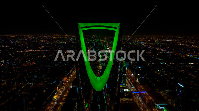 الفن الهندسي المعماري للمباني والمنشآت في العاصمة, الفخر بالانتماء للهوية الوطنية, صورة مقربة لمبنى برج المملكة المضاء باللون الأخضر في مدينة الرياض بالسعودية في وقت الليل، احتفالات اليوم الوطني السعودي في 23 سبتمبر، فعاليات يوم التأسيس السعودي 22 فبراير