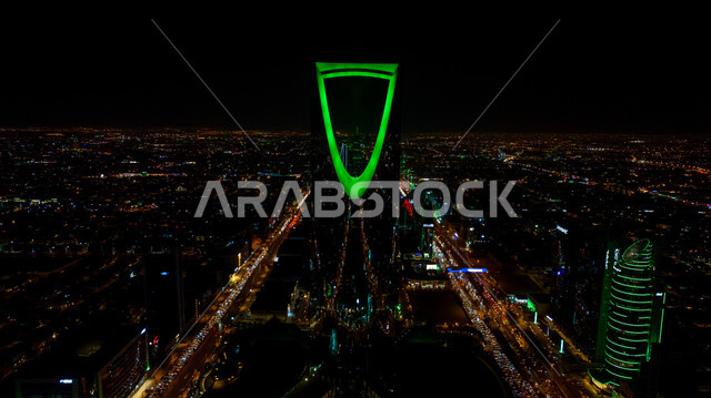 الفخر بالانتماء للهوية الوطنية, صورة مقربة لمبنى برج المملكة المضاء باللون الأخضر في مدينة الرياض بالسعودية في وقت الليل، احتفالات اليوم الوطني السعودي في 23 سبتمبر، فعاليات يوم التأسيس السعودي 22 فبراير, الفن الهندسي المعماري للمباني والمنشآت في العاصمة