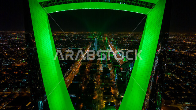الفن الهندسي المعماري للمباني والمنشآت في العاصمة, الفخر بالانتماء للهوية الوطنية, صورة مقربة لمبنى برج المملكة المضاء باللون الأخضر في مدينة الرياض بالسعودية في وقت الليل، احتفالات اليوم الوطني السعودي في 23 سبتمبر، فعاليات يوم التأسيس السعودي 22 فبراير
