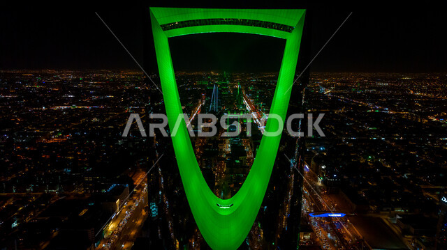 الفن الهندسي المعماري للمباني والمنشآت في العاصمة, الفخر بالانتماء للهوية الوطنية, صورة مقربة لمبنى برج المملكة المضاء باللون الأخضر في مدينة الرياض بالسعودية في وقت الليل، احتفالات اليوم الوطني السعودي في 23 سبتمبر، فعاليات يوم التأسيس السعودي 22 فبراير